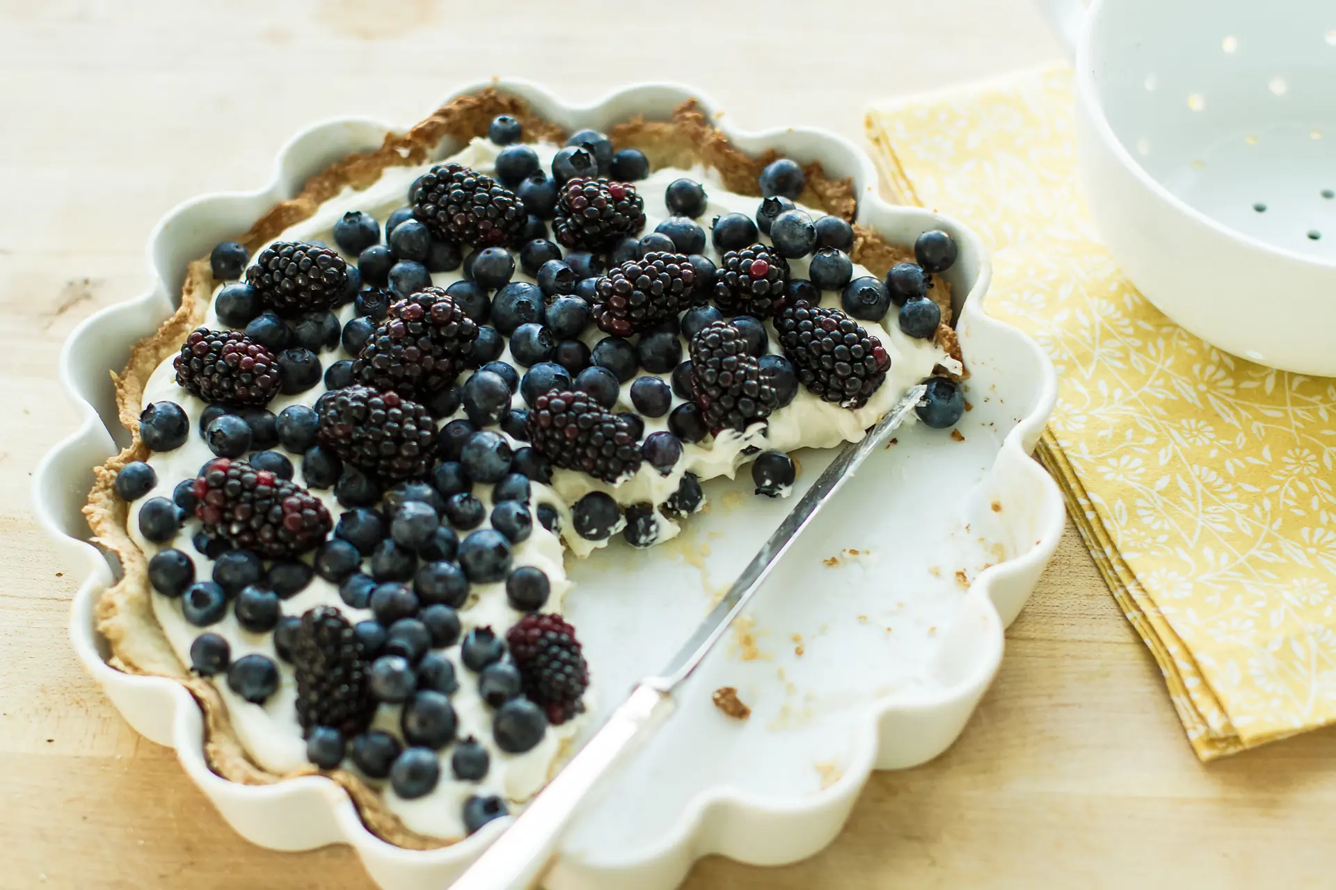 La tarte aux mûres et aux myrtilles sur sa crème, une part déjà servie