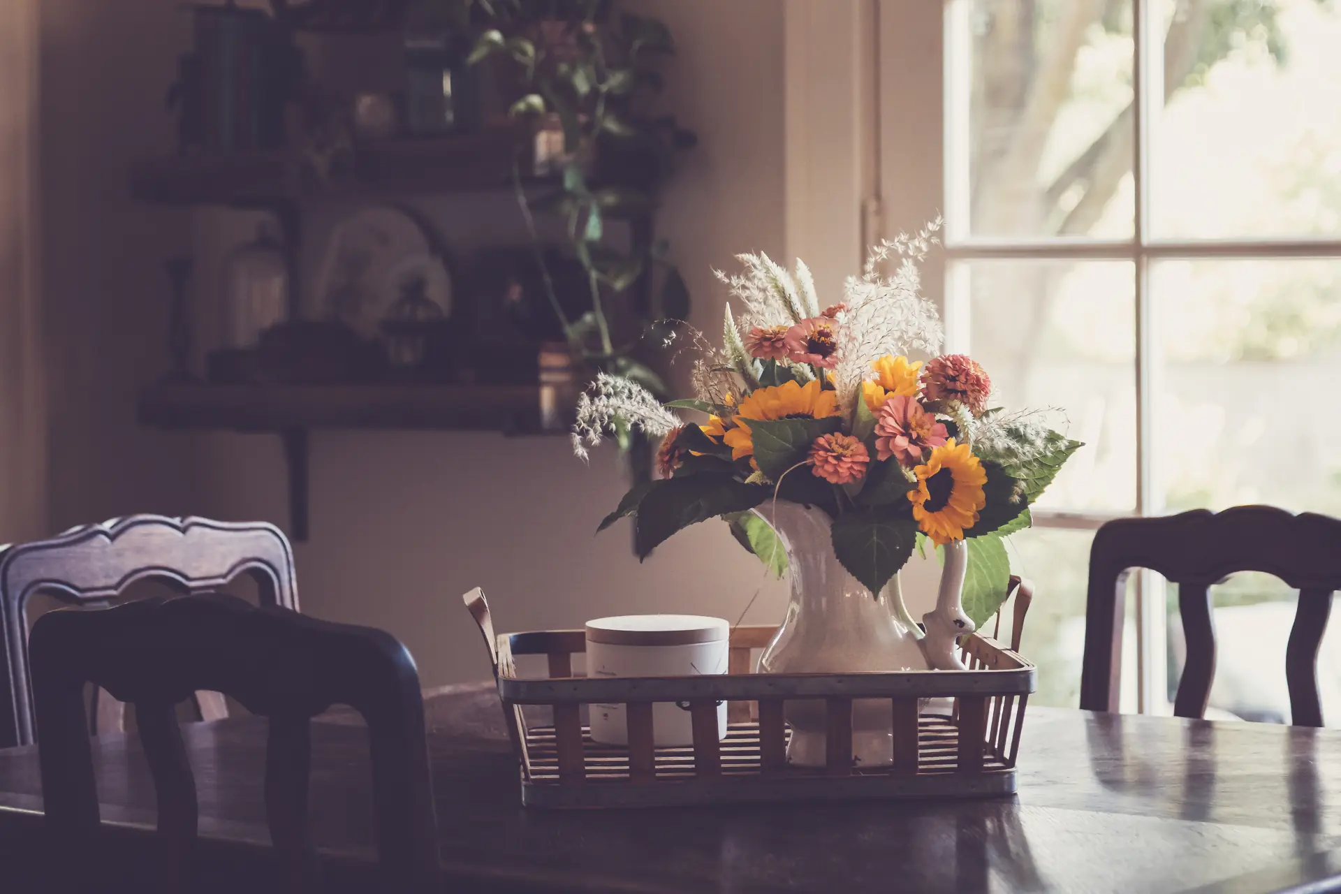 La table de la salle et son bouquet près de la fenêtre, les hortensias du jardin, des jonquilles dans un pot de grès, les ombelles du pré, une lanterne au jardin le soir