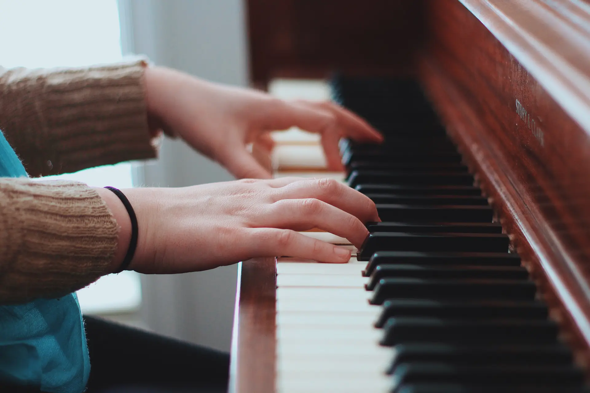 Deux mains sur le clavier du piano de la salle